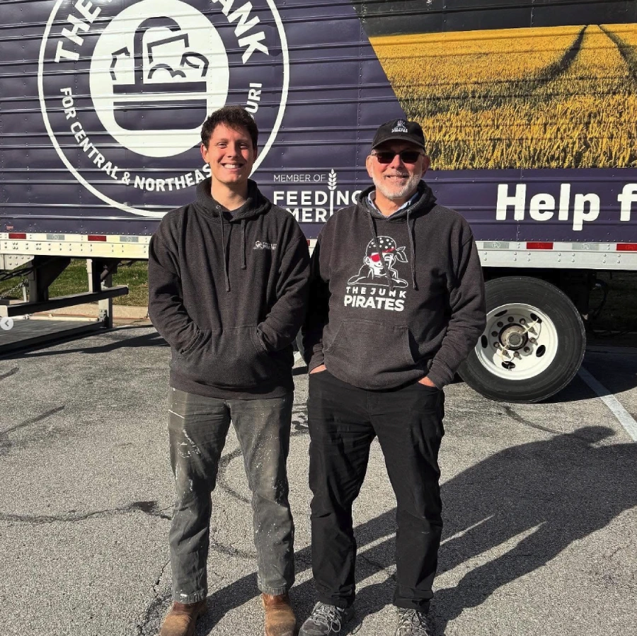 Two Junk Pirates crew members in front of the Feeding America Food Bank semi-trailer.